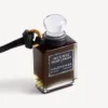 Bedeltje in de vorm van een miniatuurparfumflesje in zwart