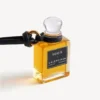 Bedeltje in de vorm van een miniatuurparfumflesje in zwart